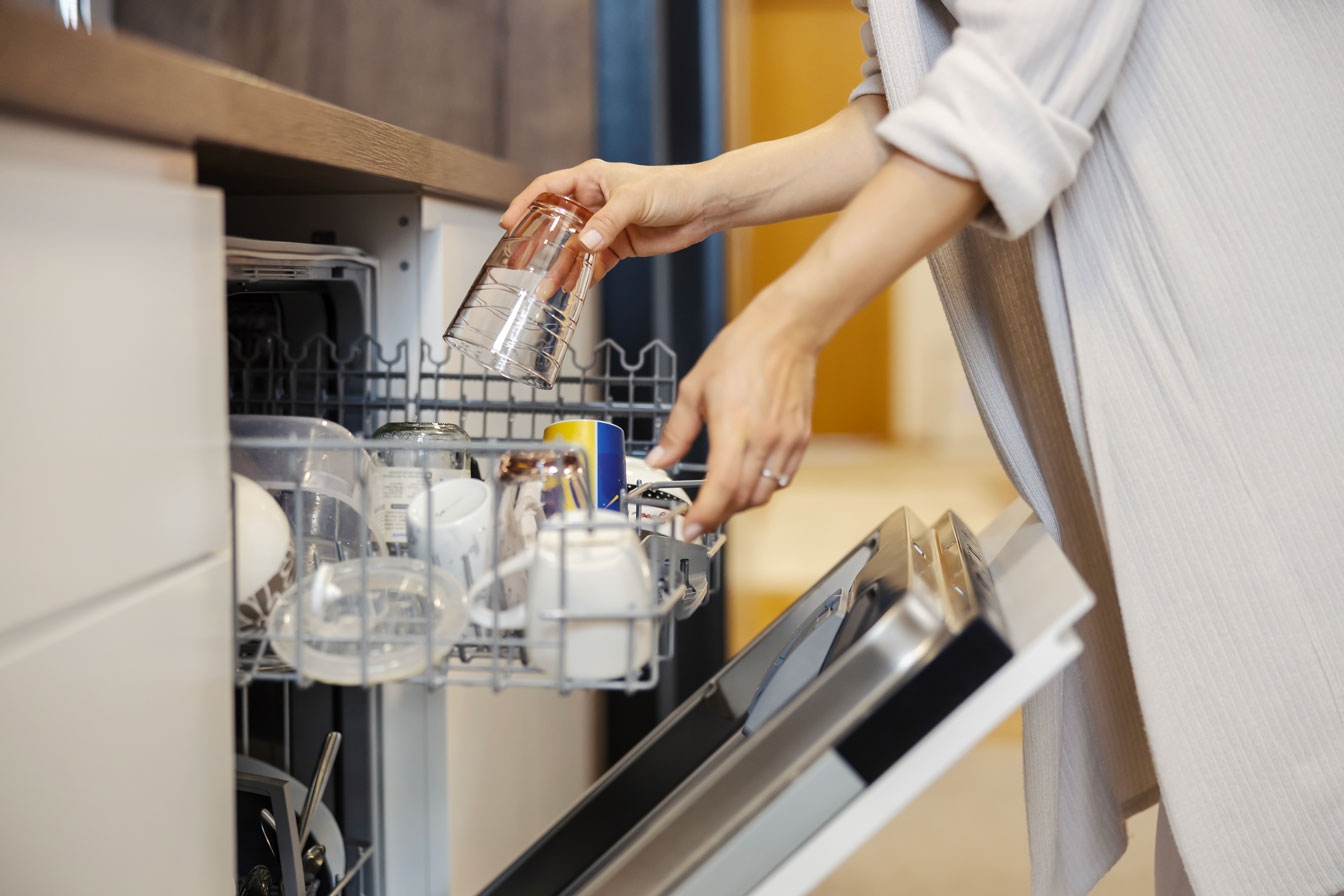 close-up-woman-putting-dishes-into-dishwasher-home.jpg